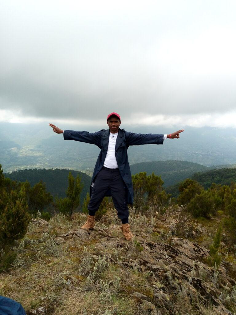 Image contains a hiker enjoying the breeze at Mt. Kipipiri Summit