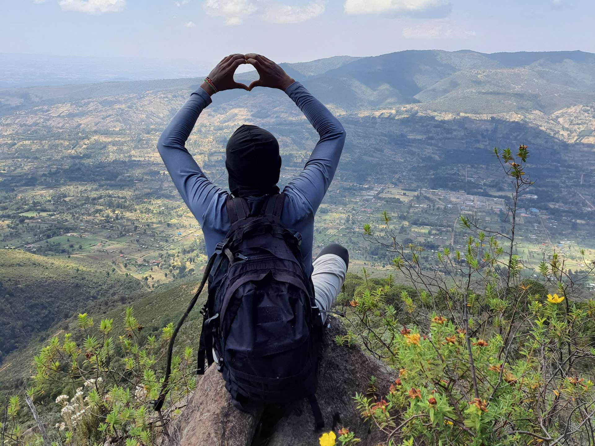 a hker sitting on a rock taking landscape views along the rurimeria hiking trail